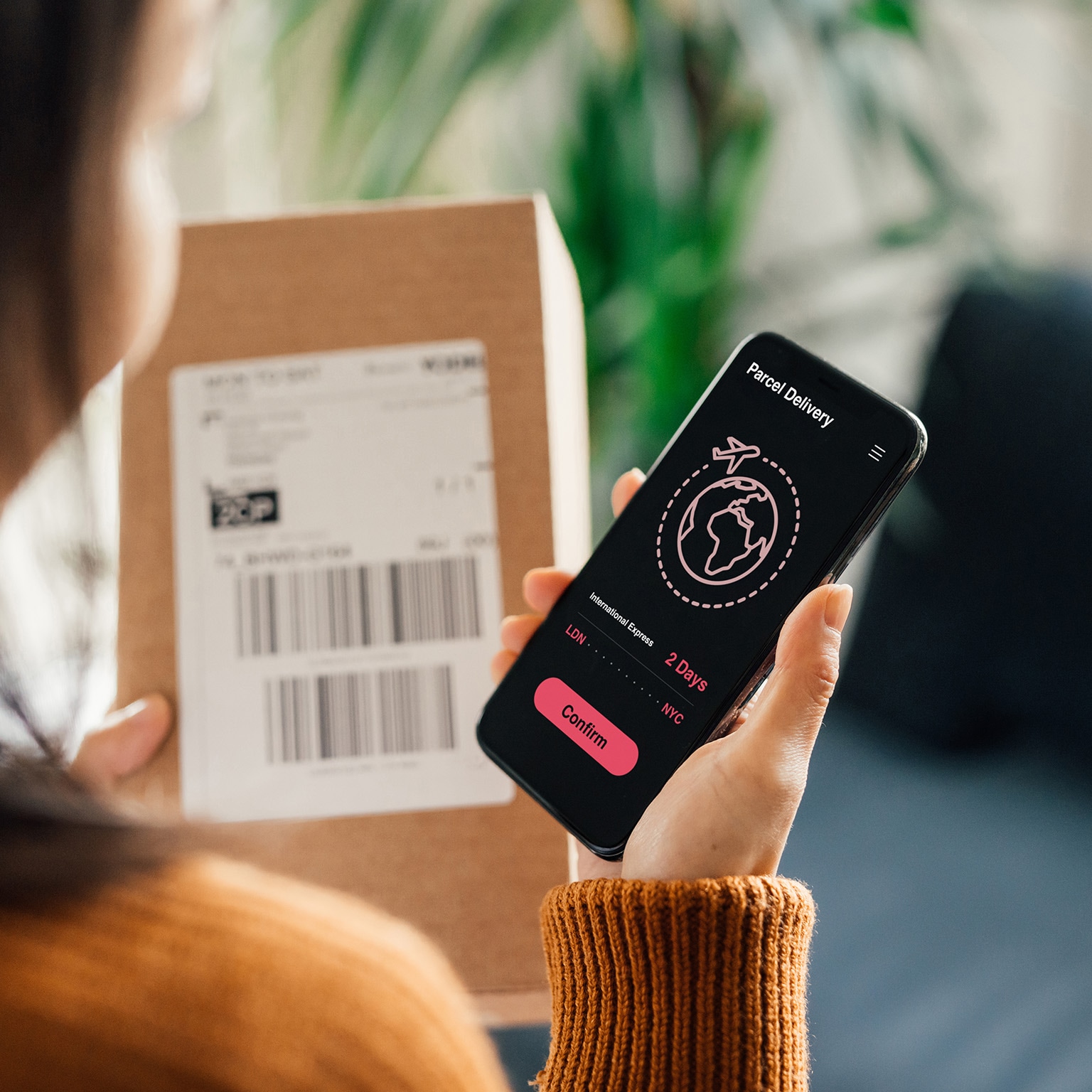 woman receiving parcel delivery on mobile phone