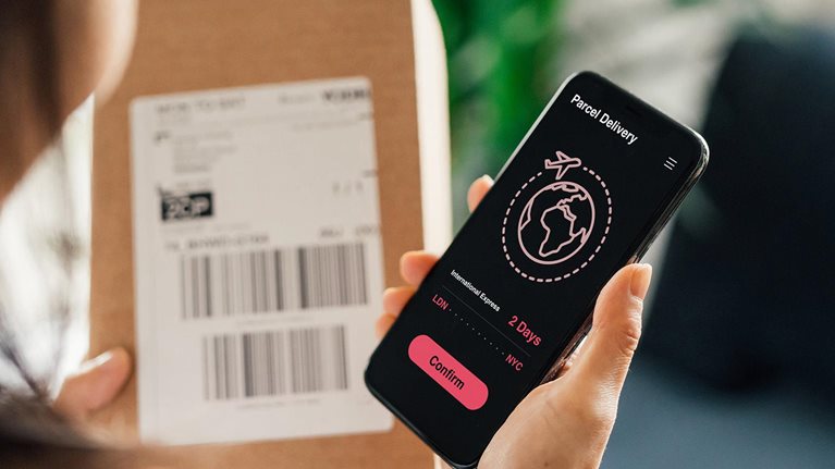 woman receiving parcel delivery on mobile phone