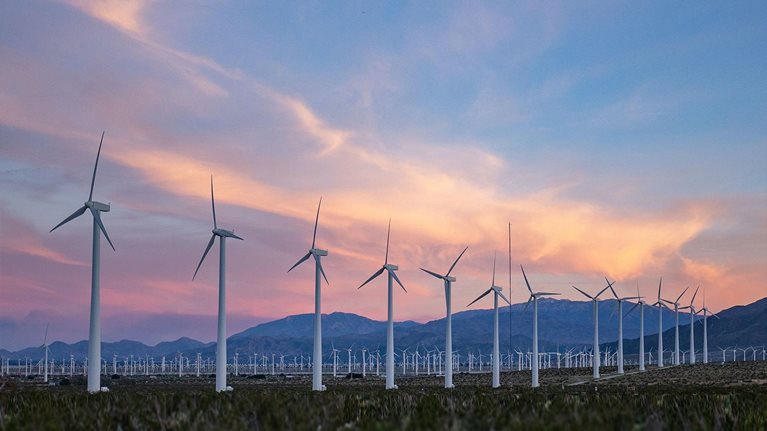sunset falls as wind turbines spin