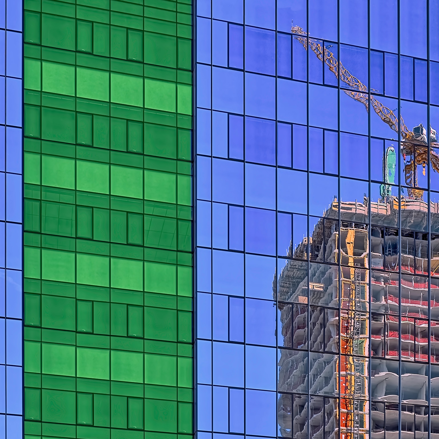 reflection of crane in glass on side of building stock photo