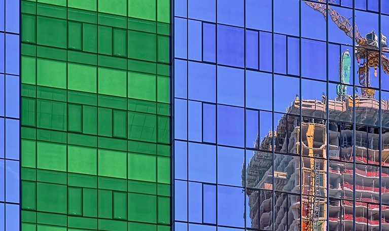 reflection of crane in glass on side of building stock photo