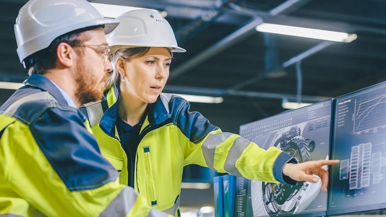 Inside Factory Male Mechanical Engineer and Female Chief Engineer Work Together on the Personal Computer, They Discuss Details of the 3D Engine Model Design.