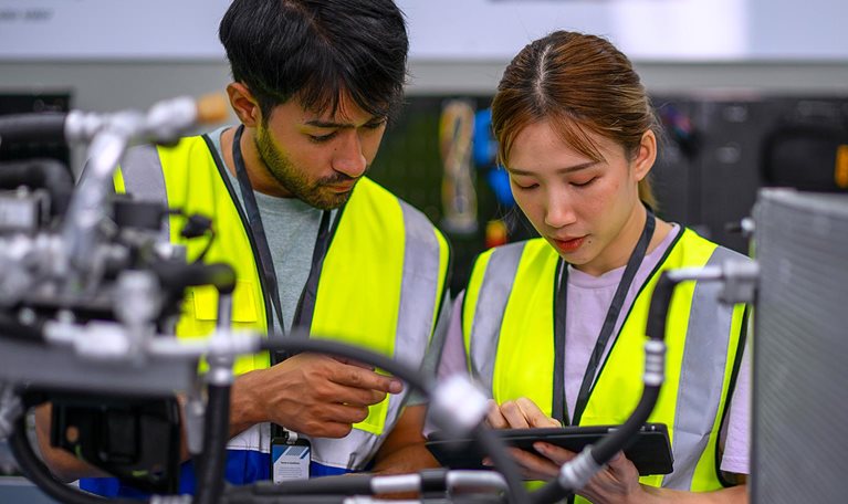 Mechanics are working at EV car workshop.
