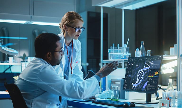 Female Research Scientist with Bioengineer Working on a Personal Computer with Screen Showing DNA Analysis Software User Interface. Scientists Developing Vaccine, Drugs and Antibiotics in Laboratory