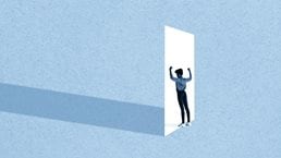 Full length of young woman flexing muscles while standing in front of white doorway against blue background