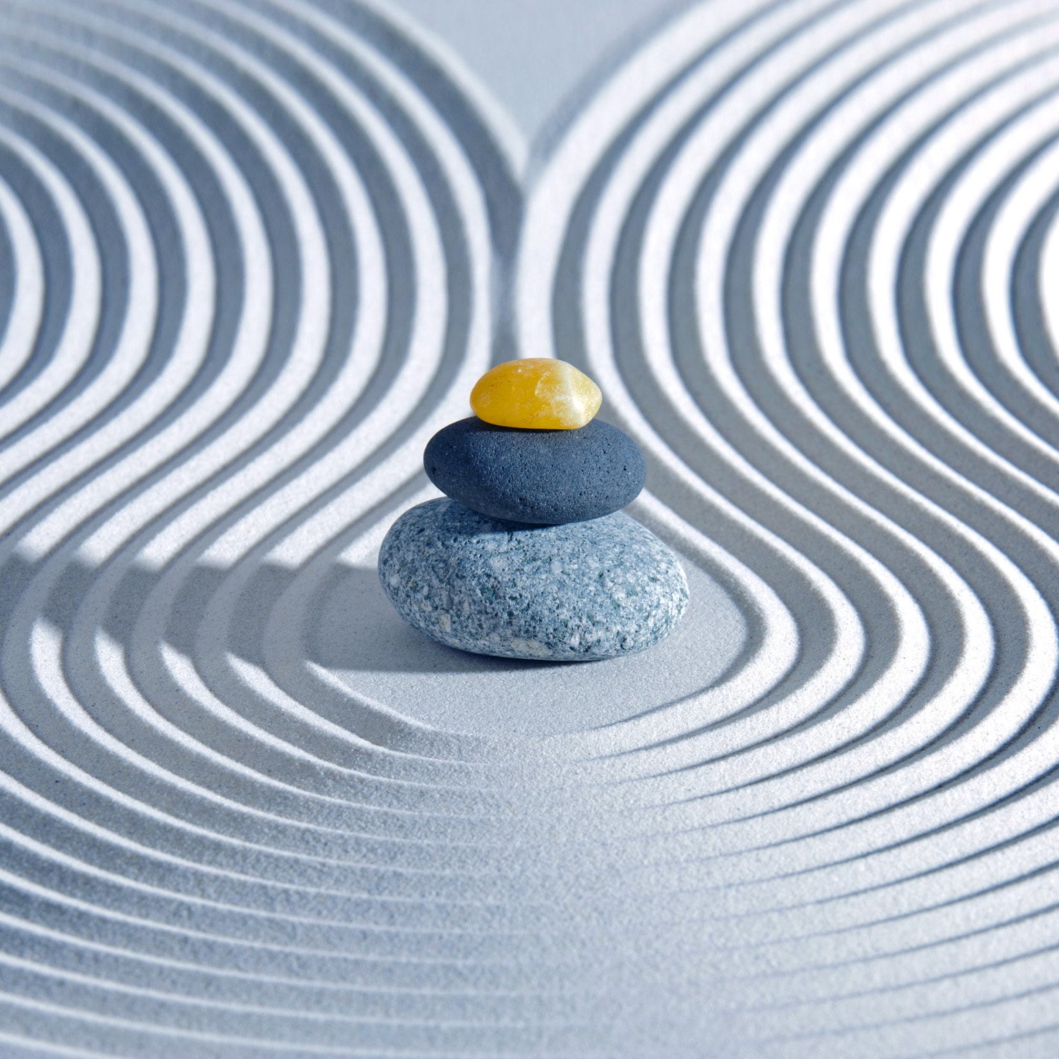 Japanese Zen garden with swirls in the sand & pebble stack