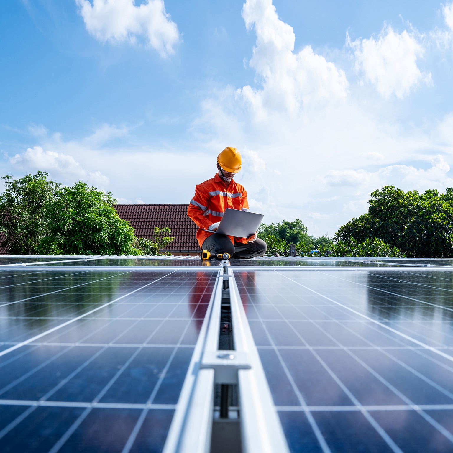 Technicians man working with laptop at solar power station on the roof, Solar energy technology concept - stock photo