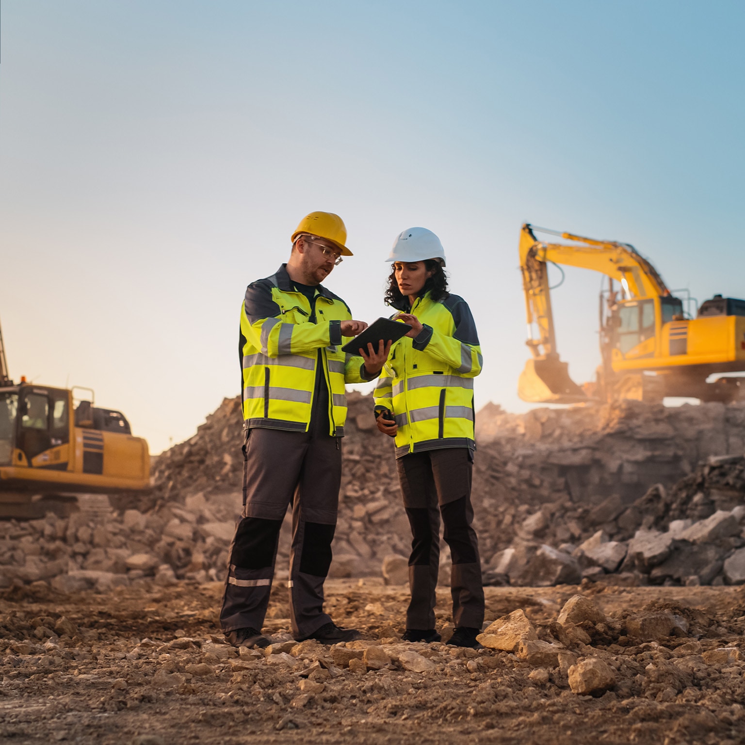 Using Tablet On Construction Site of New Apartment Complex. Real Estate Developers Discussing Business, Excavators Working.