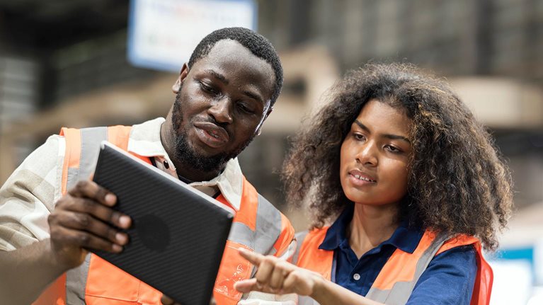 Production Control Engineers is having discussion on production daily report for resource planning related to production on tablet in factory shop floor. - stock photo