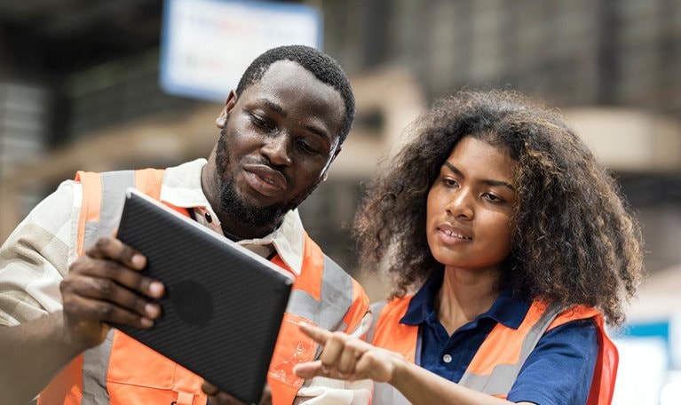 Production Control Engineers is having discussion on production daily report for resource planning related to production on tablet in factory shop floor. - stock photo