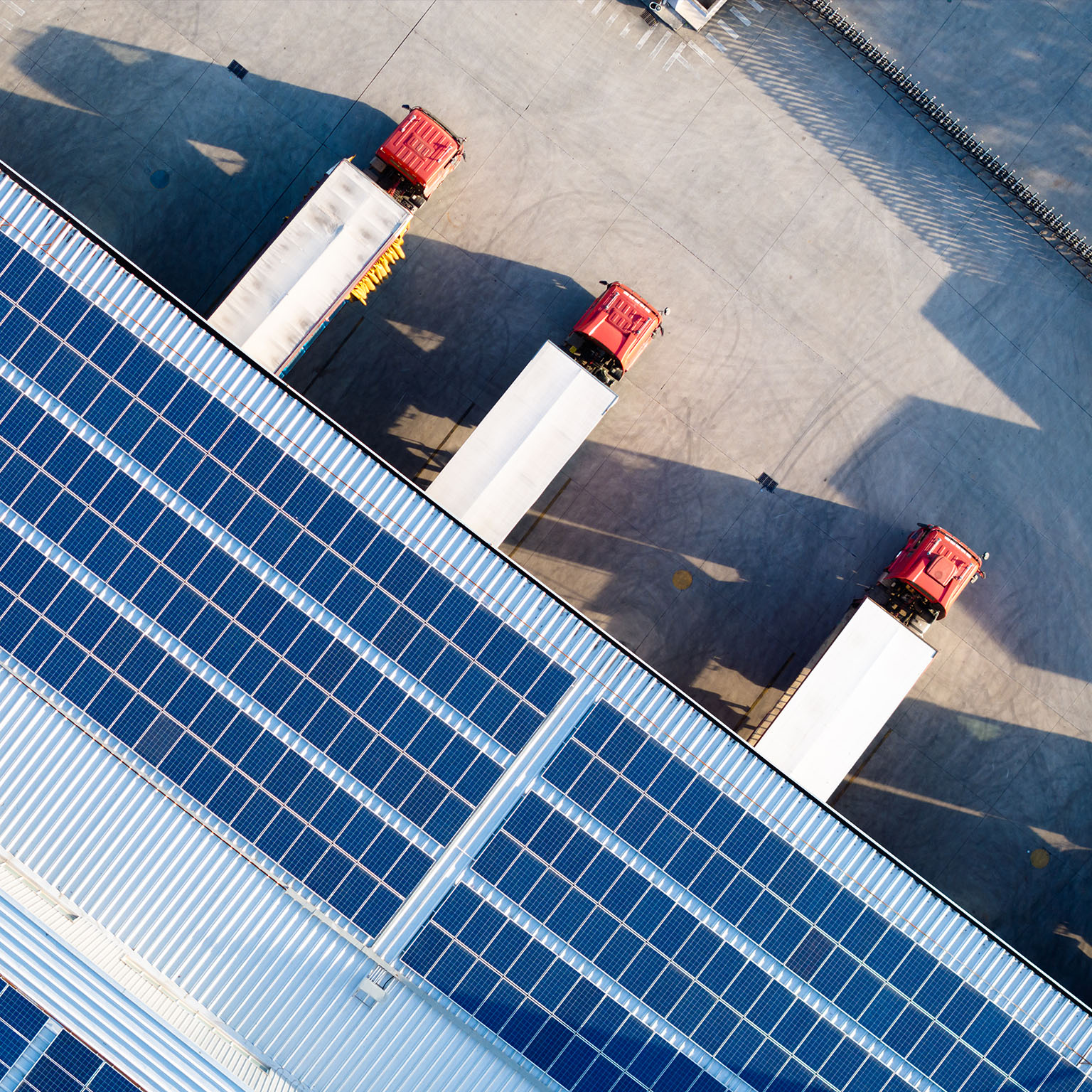 Truck loading in warehouse, solar panels on factory rooftop - stock photo
