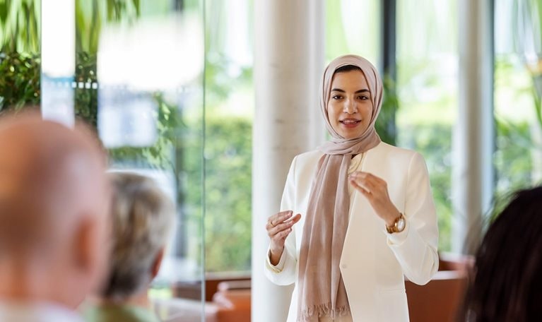 Muslim businesswoman addressing the audience in a conference - stock photo