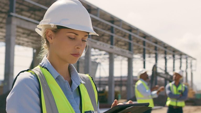 Female person and engineering worker on digital technology at industrial architecture design - stock photo