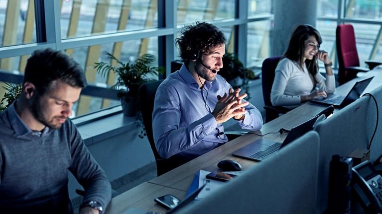 Business people working on laptops in a call center
