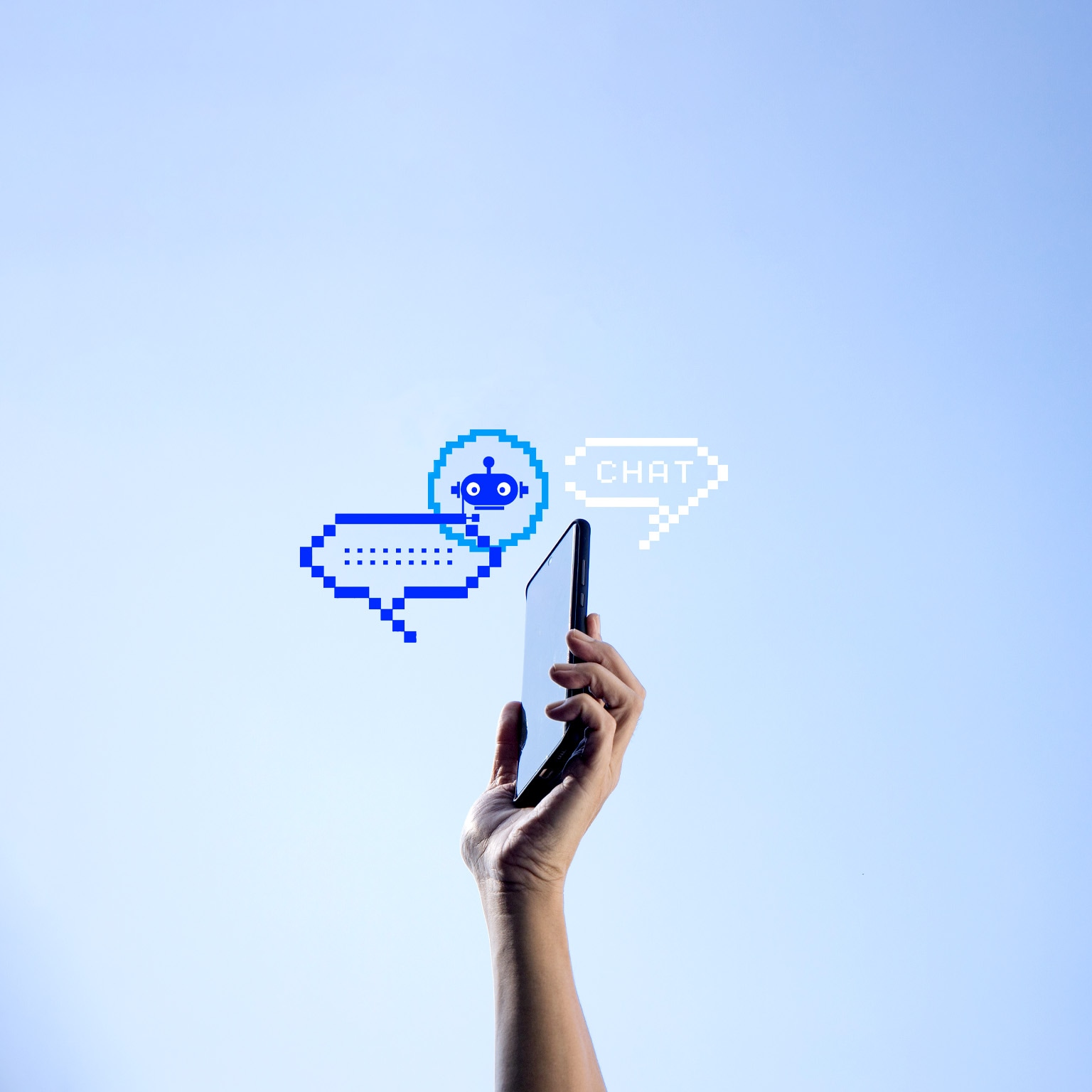 A hand holding a mobile phone with two pixelated chat bubbles and an AI bot icon against a clear blue sky.