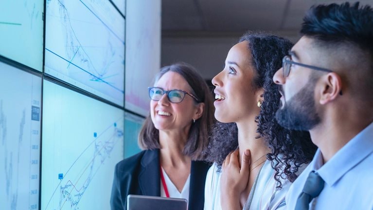 UK, York, Business people discussing charts on interactive screens