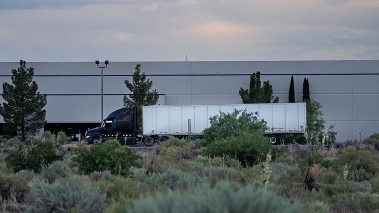 Semi truck on highway in front of a building near the US/Mexico border