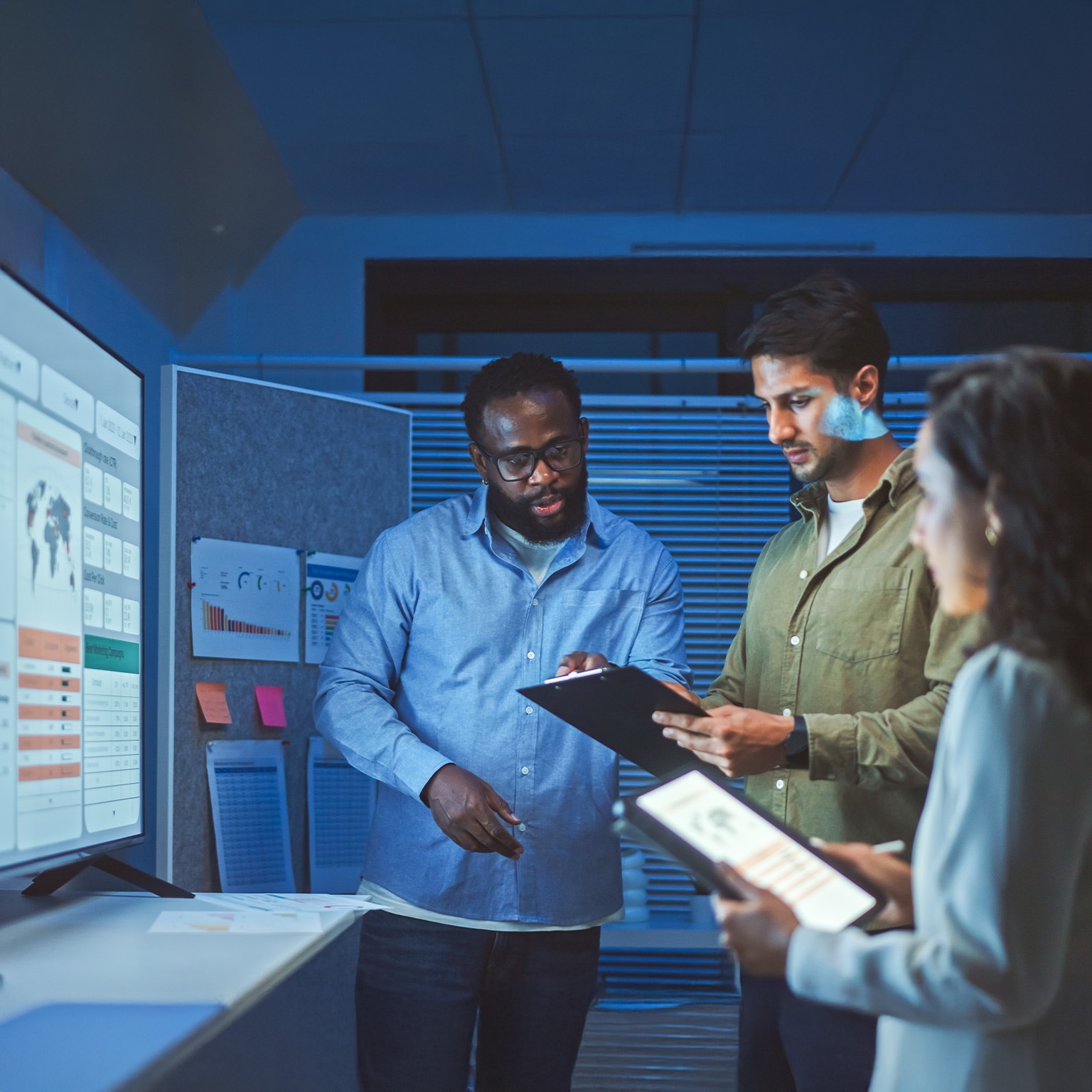 A team of multiethnic developers is meeting to review the data analysis of marketing from social media platforms.