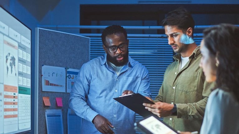 A team of multiethnic developers is meeting to review the data analysis of marketing from social media platforms.