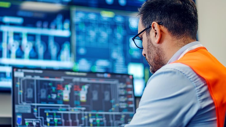 Engineer monitoring industrial process control system