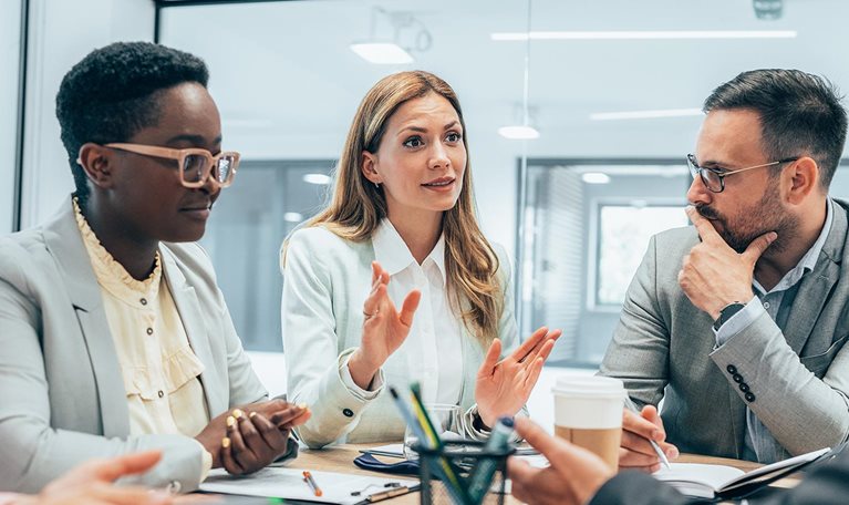 Modern business team smiling and talking in board room discussing new ideas at the office.