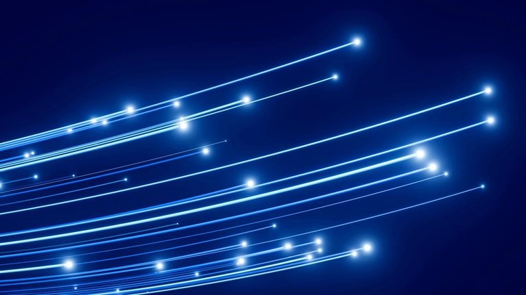 Abstract image of curved blue light trails with glowing points on a dark blue background.