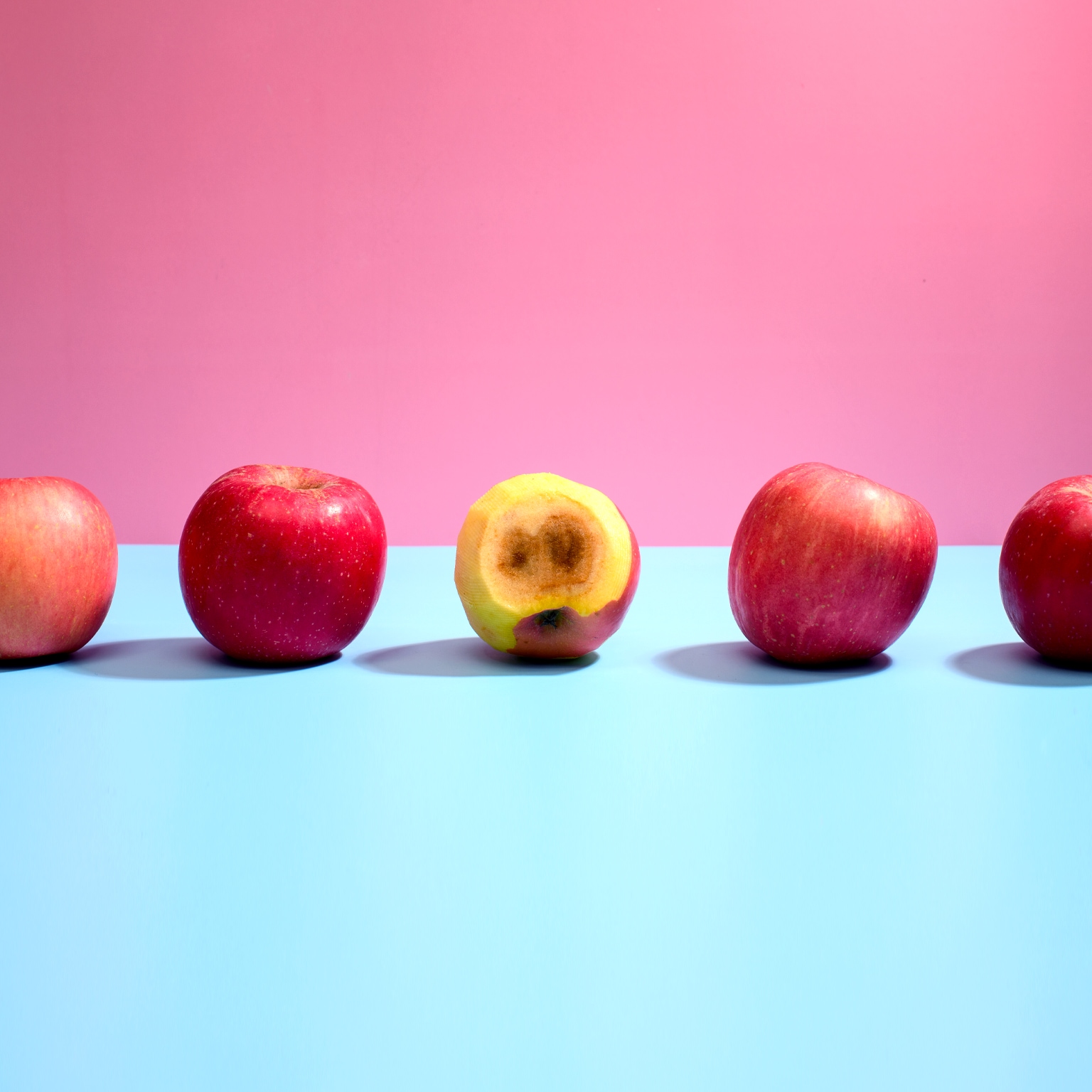 Rotten apple among good ones in a row.