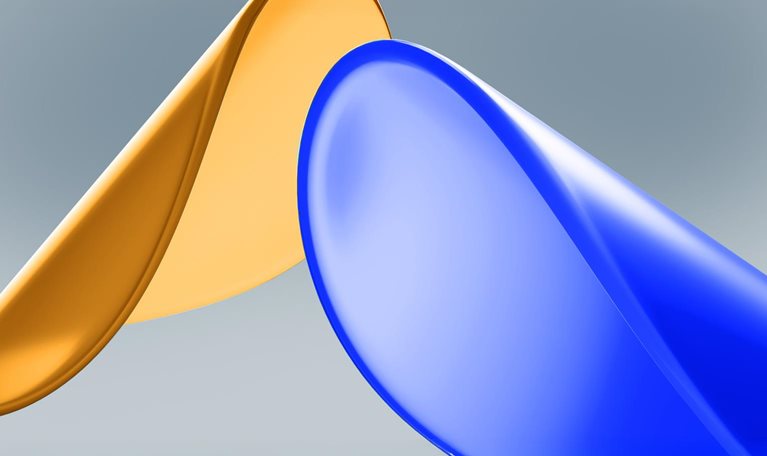 Two smooth, glossy disk-like shapes set against a soft gray background: one golden and the other blue. The lighting and reflective surfaces give the composition a sleek appearance.