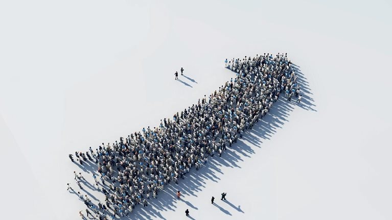 An arrow arching upward made out of a growing crowd of people.