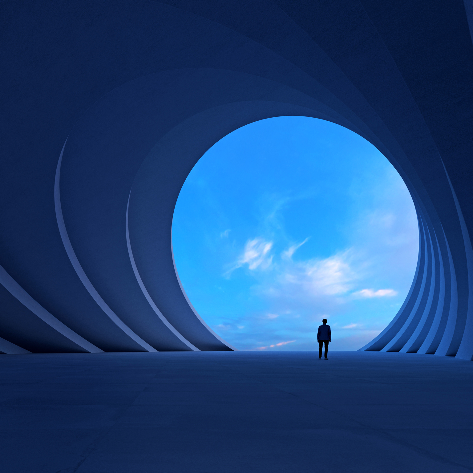 A person stands in a vast blue architectural space, looking through a large circular opening toward a bright sky.
