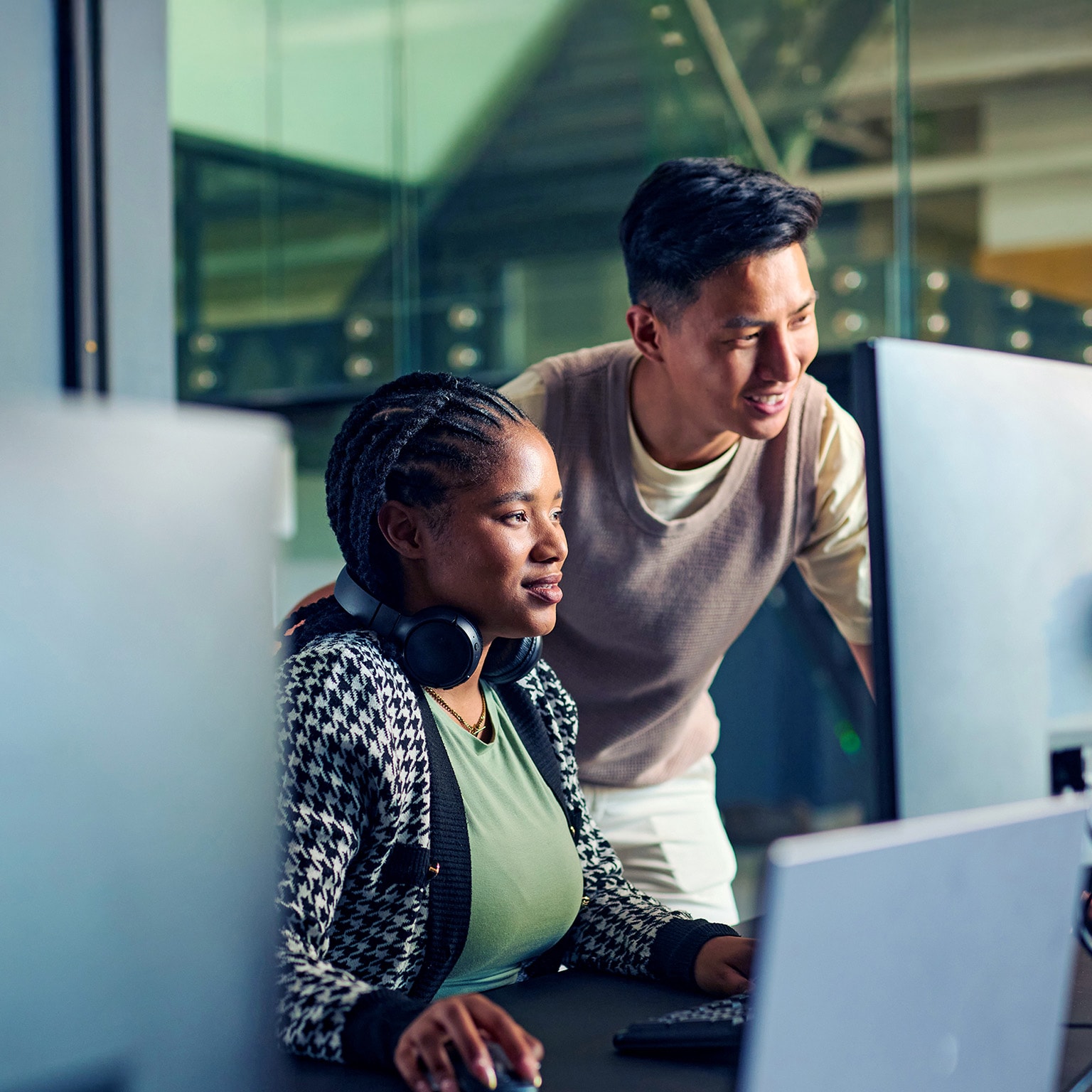 Software engineers huddled over a computer screen, collaborating on a project