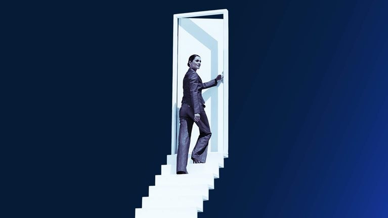 Businesswoman opening door at end of stairway