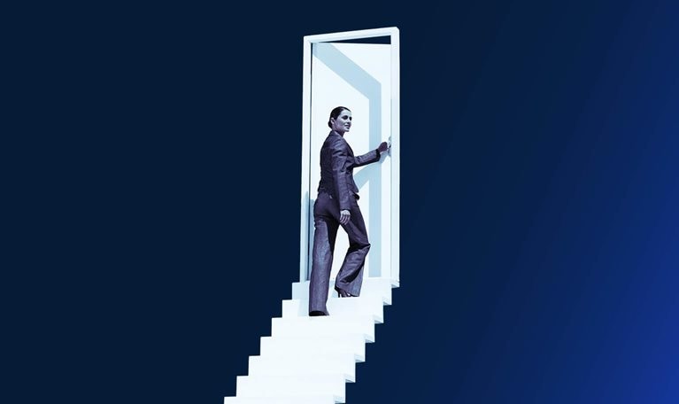 Businesswoman opening door at end of stairway