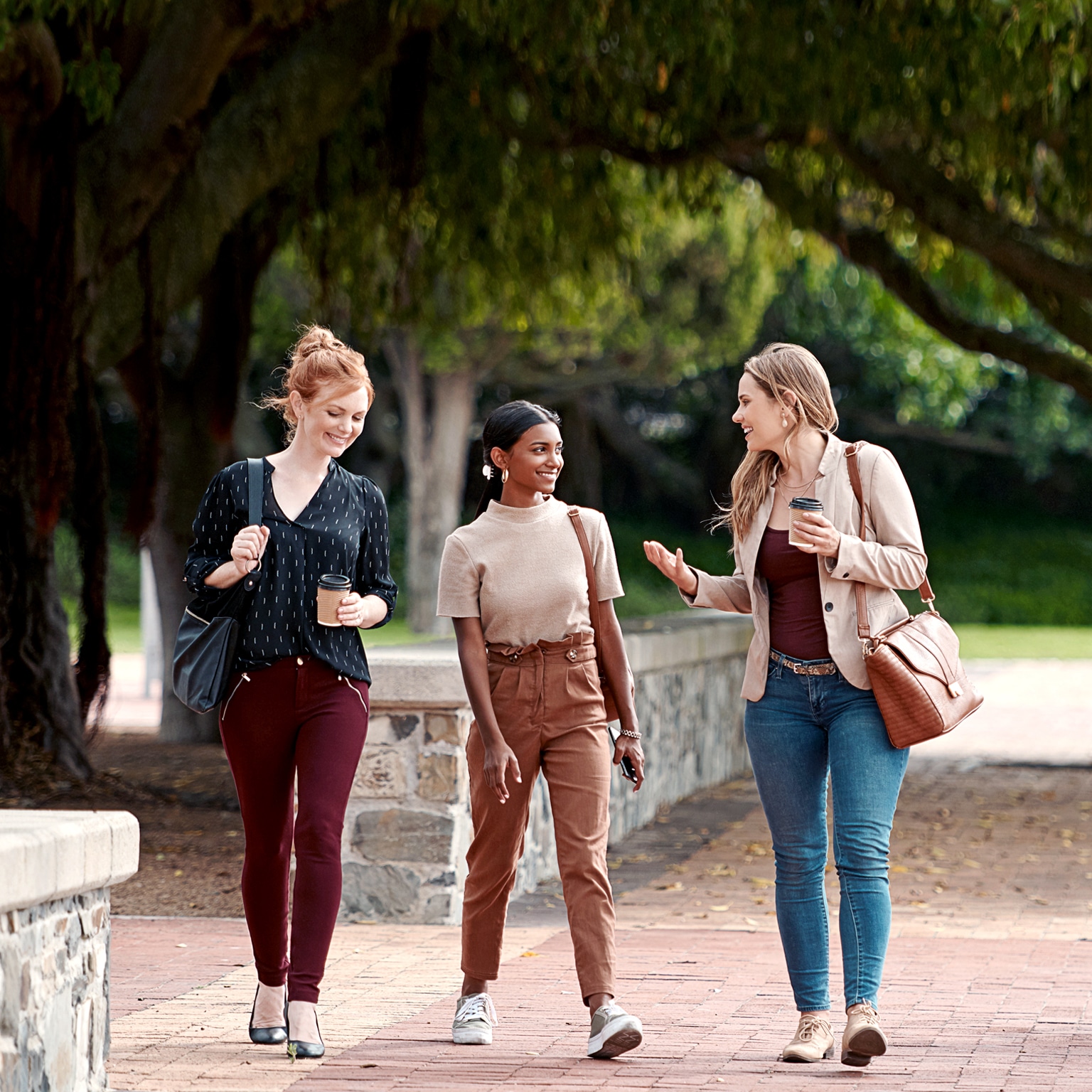  Shot of a group of young businesspeople chatting while walking through the city