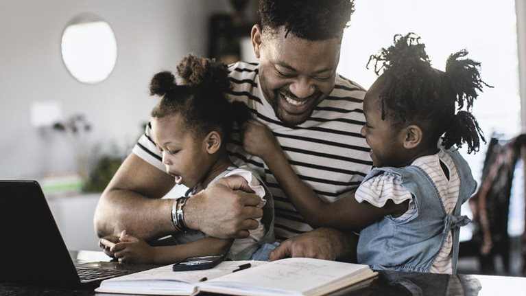 Working dad hugging kids
