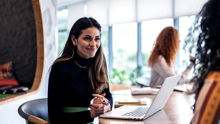 A woman interviewing a candidate with an enthusiastic expression on her face.