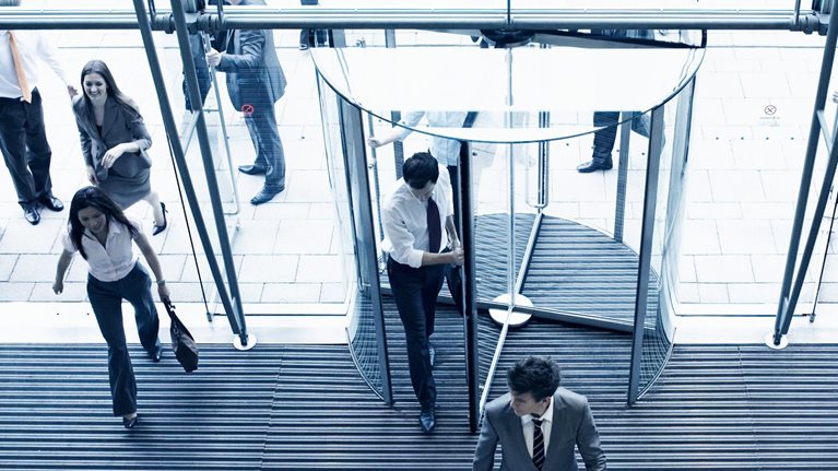 Employees entering their office though multiple doors in the lobby