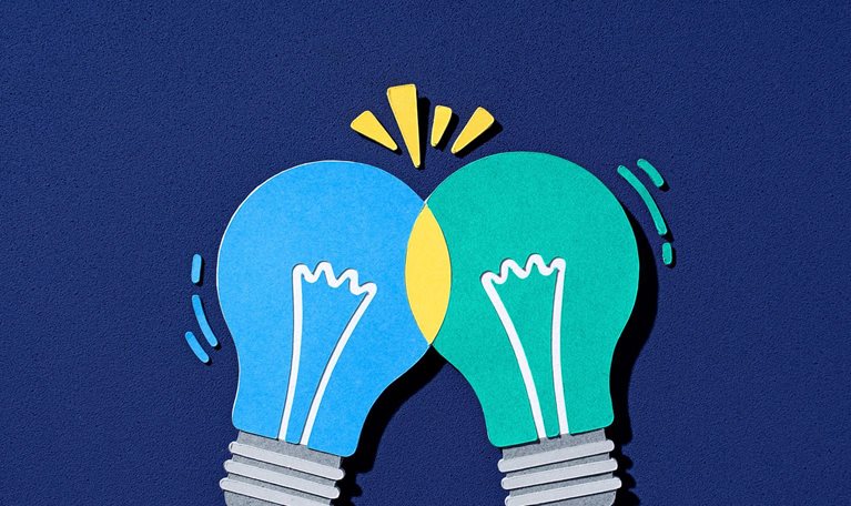 Paper-cut illustration of two lightbulbs intersecting