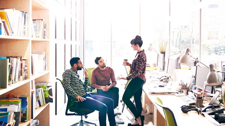 Creative coworkers chatting over ideas in office