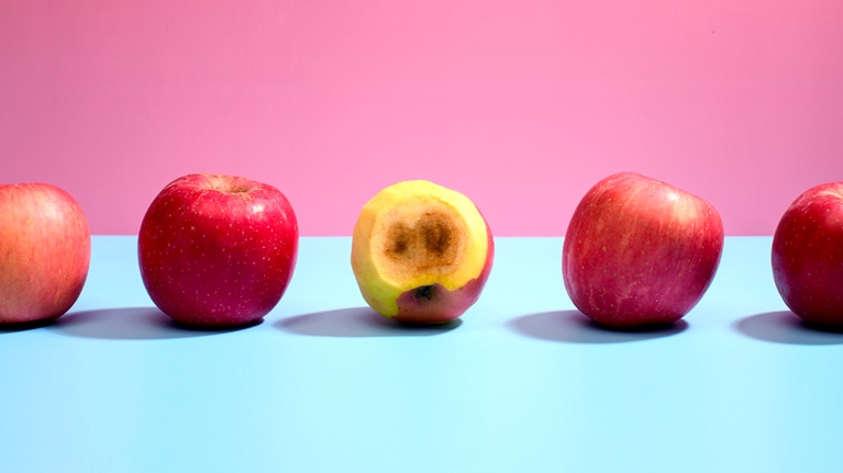 Rotten apple among good ones in a row.