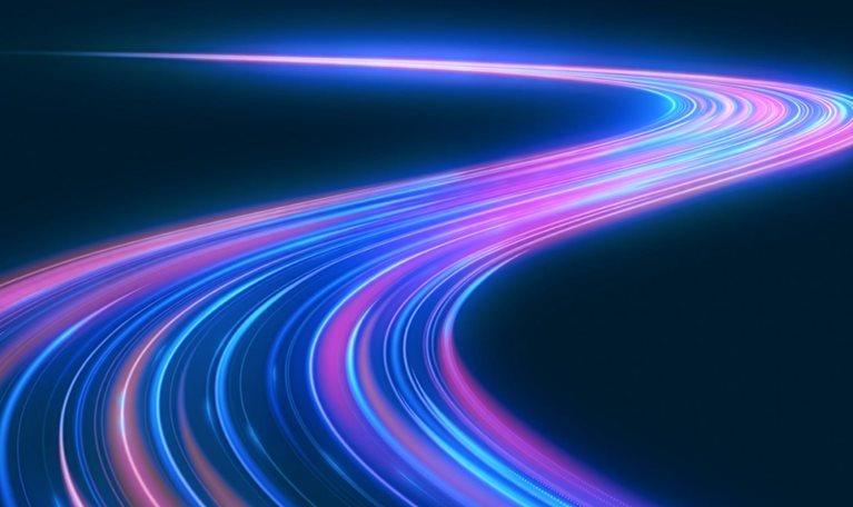 Glowing blue, purple, and pink light trails curve through a dark blue space, forming a sweeping path that winds toward the horizon, suggesting acceleration, technological progress, or the evolving direction of AI.