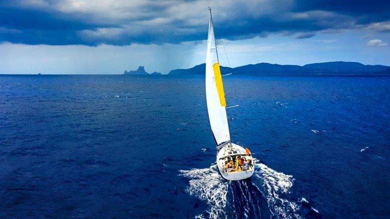Aerial view of a yacht in a storm with a dramatic sky