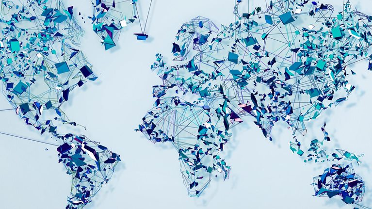 A world map made up of geometric shapes resembling shards of glass and thin lines connecting them. 