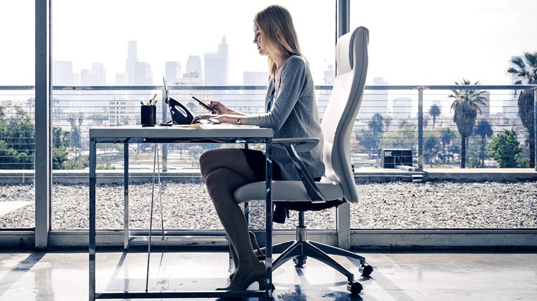 Side view of female entrepreneur sitting at desk working in office