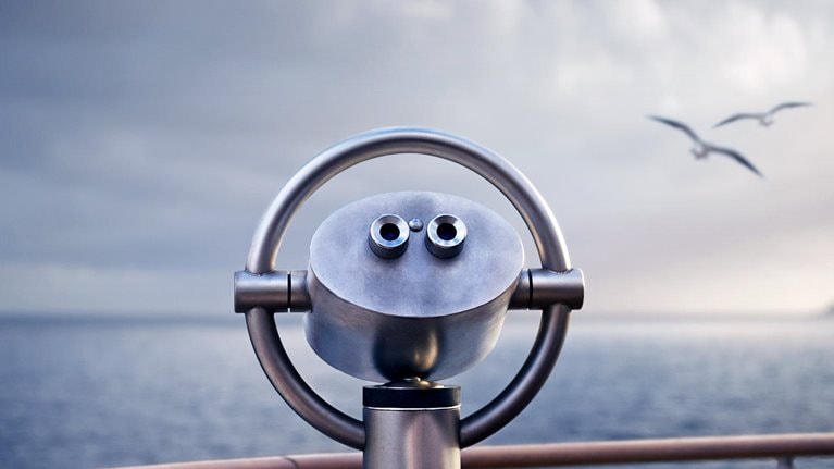 Telescope on a ship with two birds flying over the water in the background