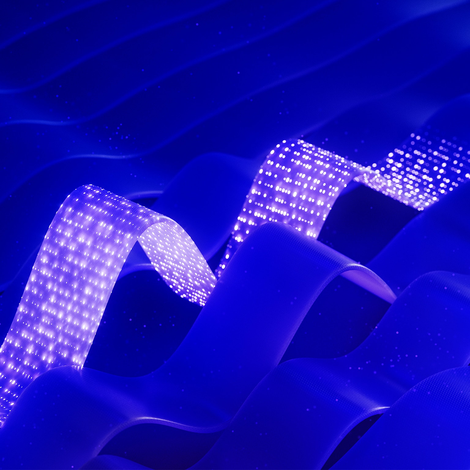 Abstract blue waves with two glowing dotted ribbons creating a futuristic, digital effect.