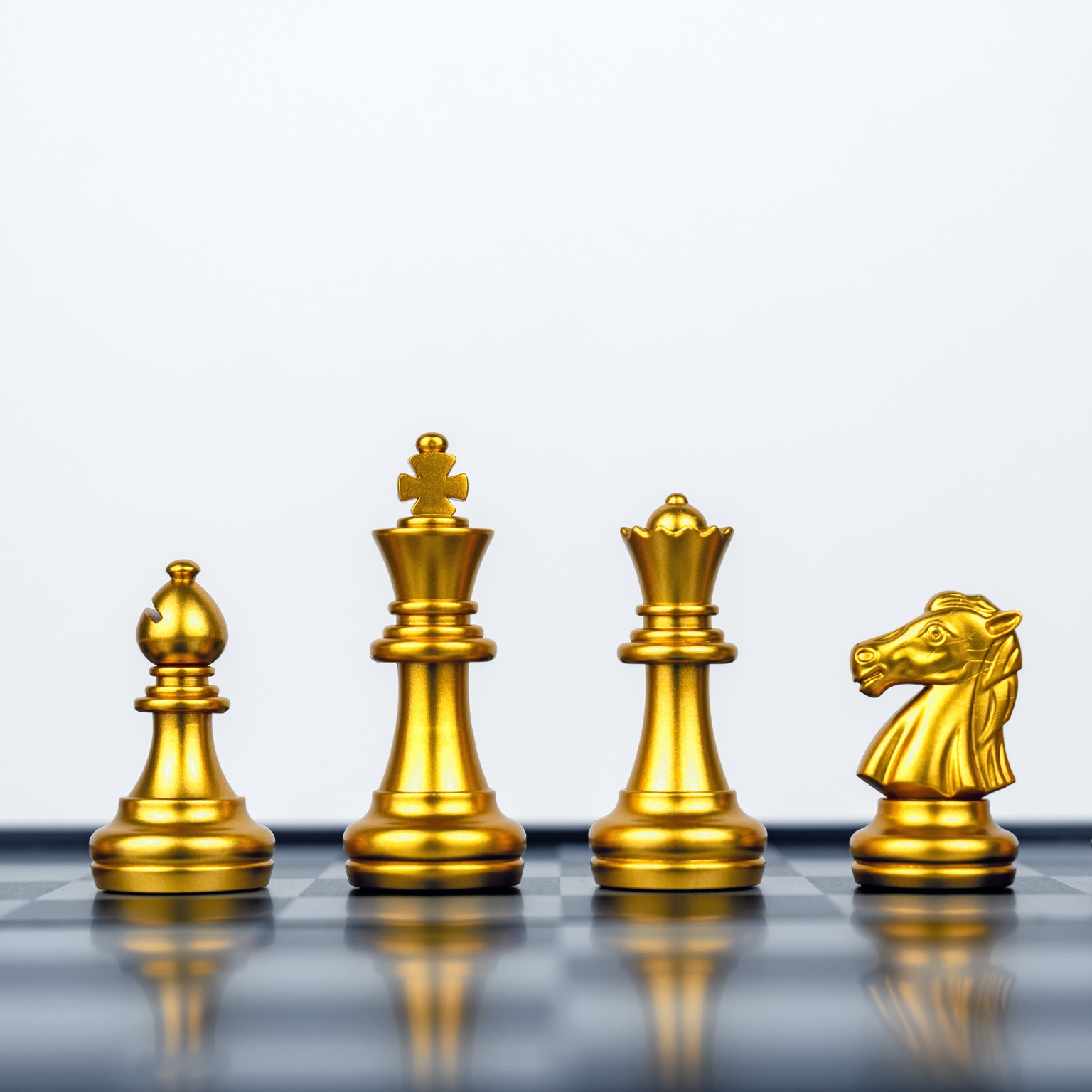 Six golden chess pieces stand proudly in a row on the board. From left to right, we have a pawn, a bishop, a knight, a king, a queen, and a rook.