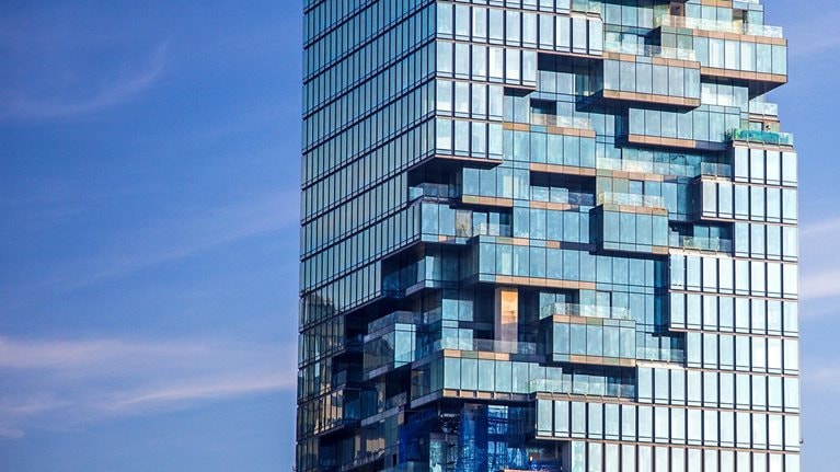 Tall building with special design showing internal glass structure in the center.