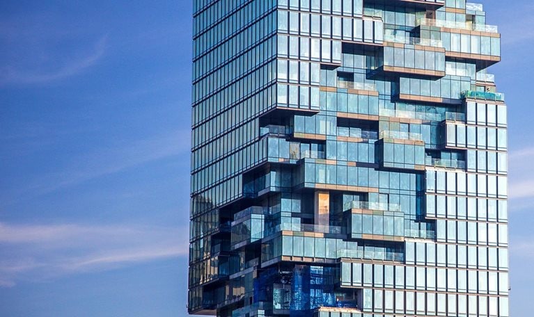 Tall building with special design showing internal glass structure in the center.