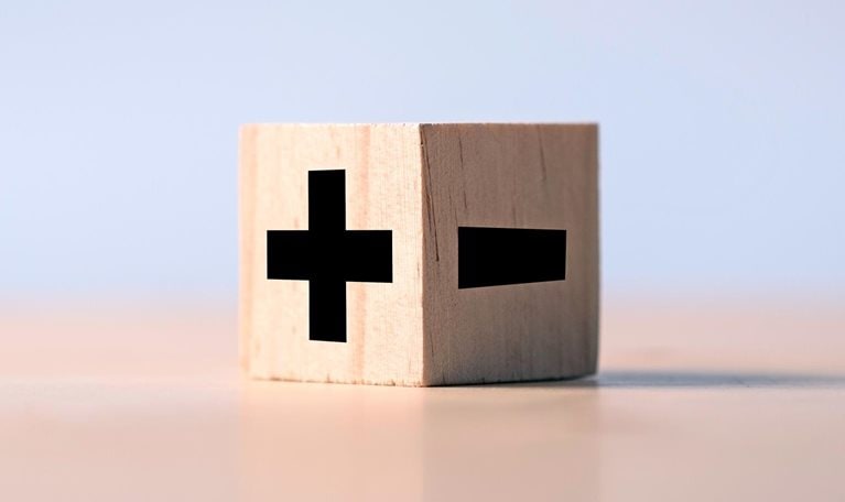 A wooden block marked with a positive and negative sign